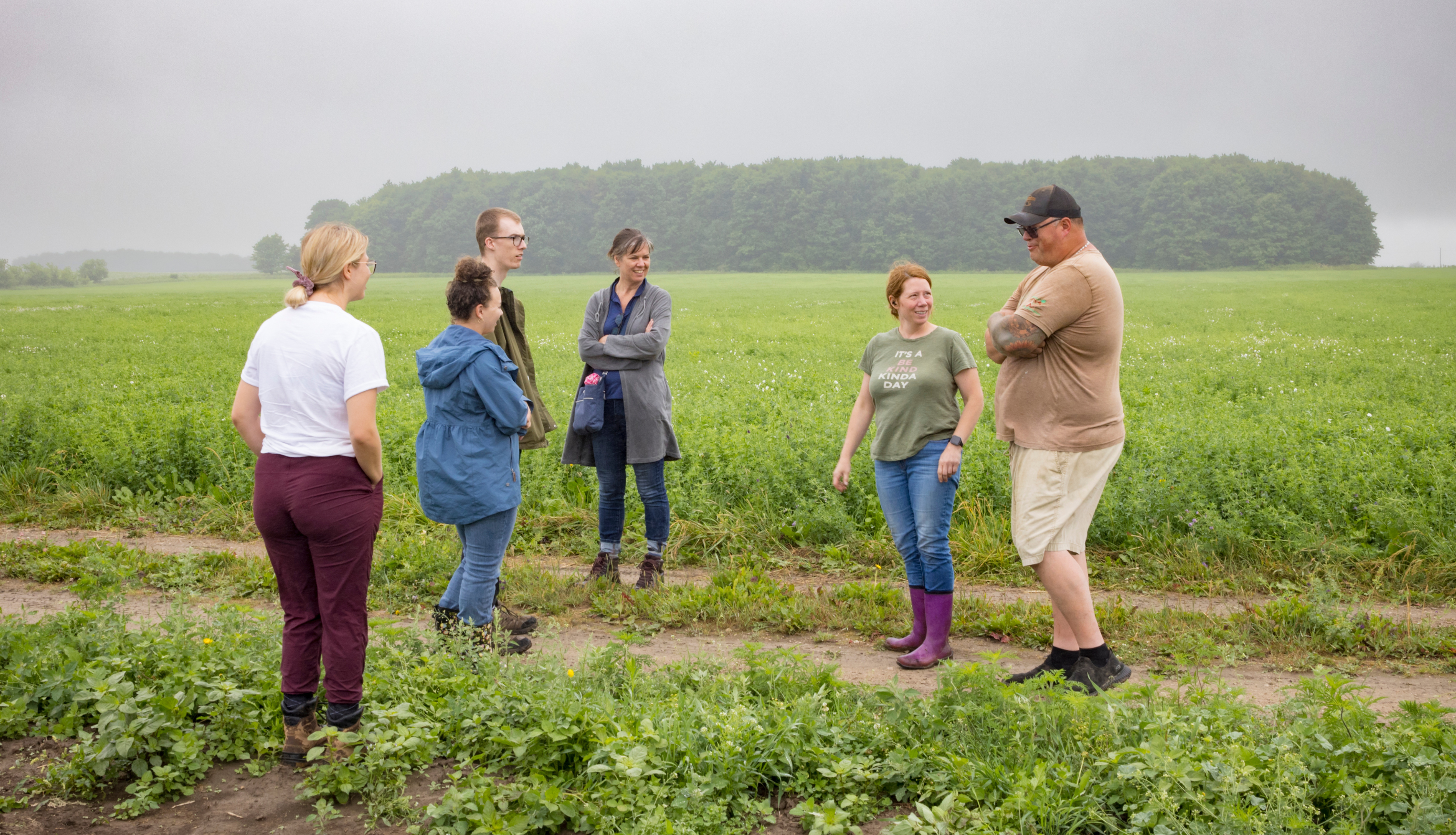 A group of people tour the fields of the Experimental Acres farm in Dufferin County.