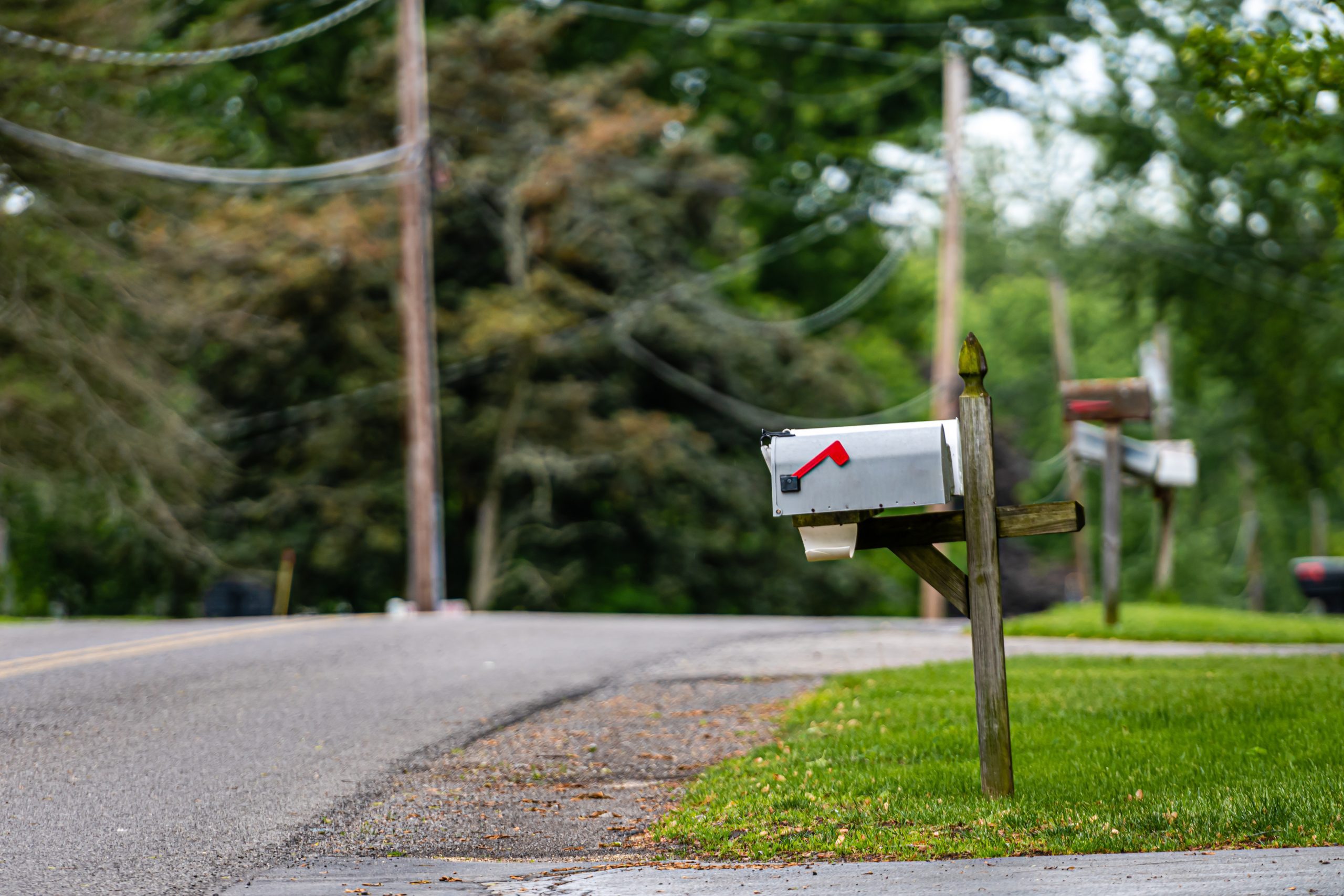 A mailbox sits at the end of a laneway by the road