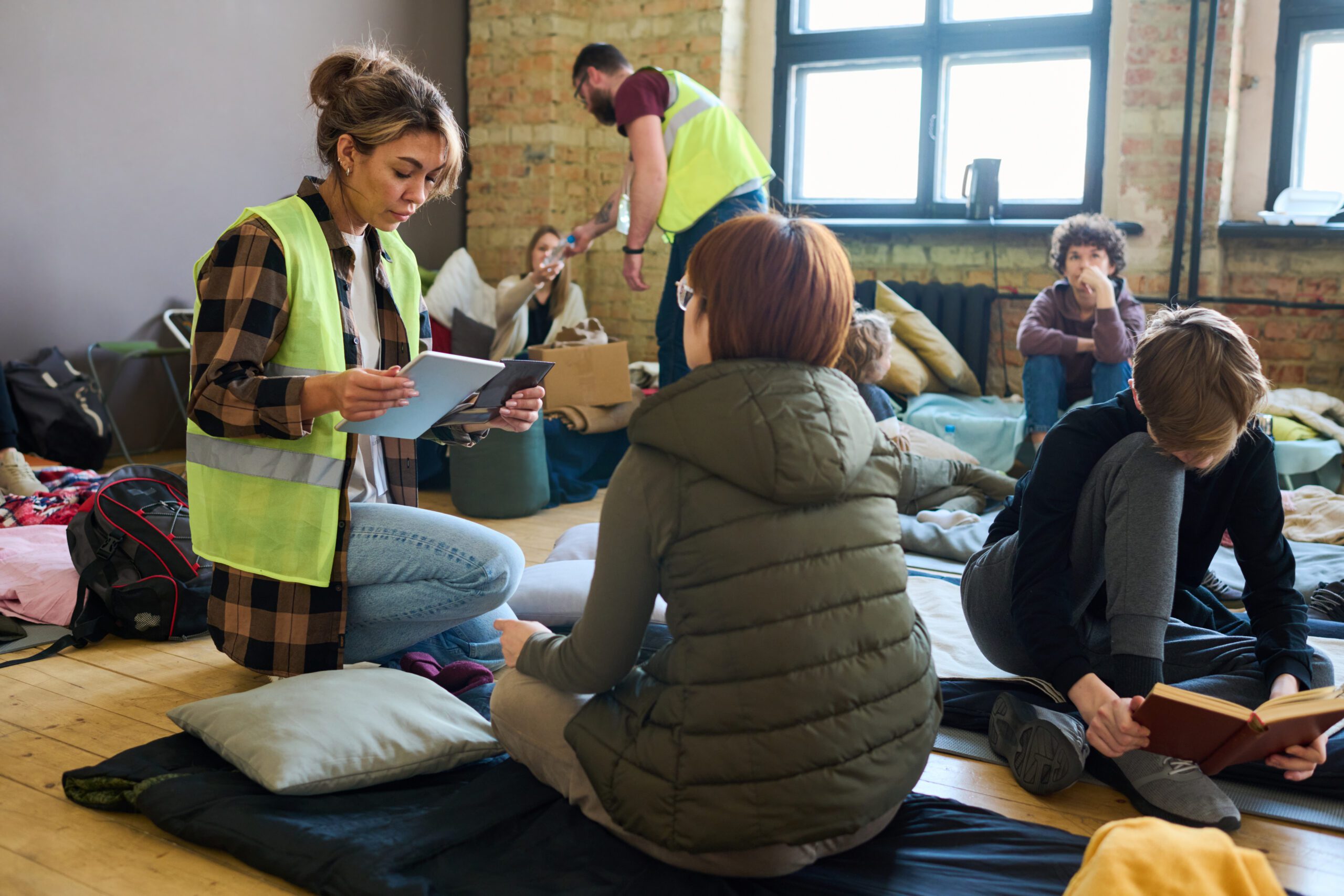 An emergency shelter volunteer speaks to community members