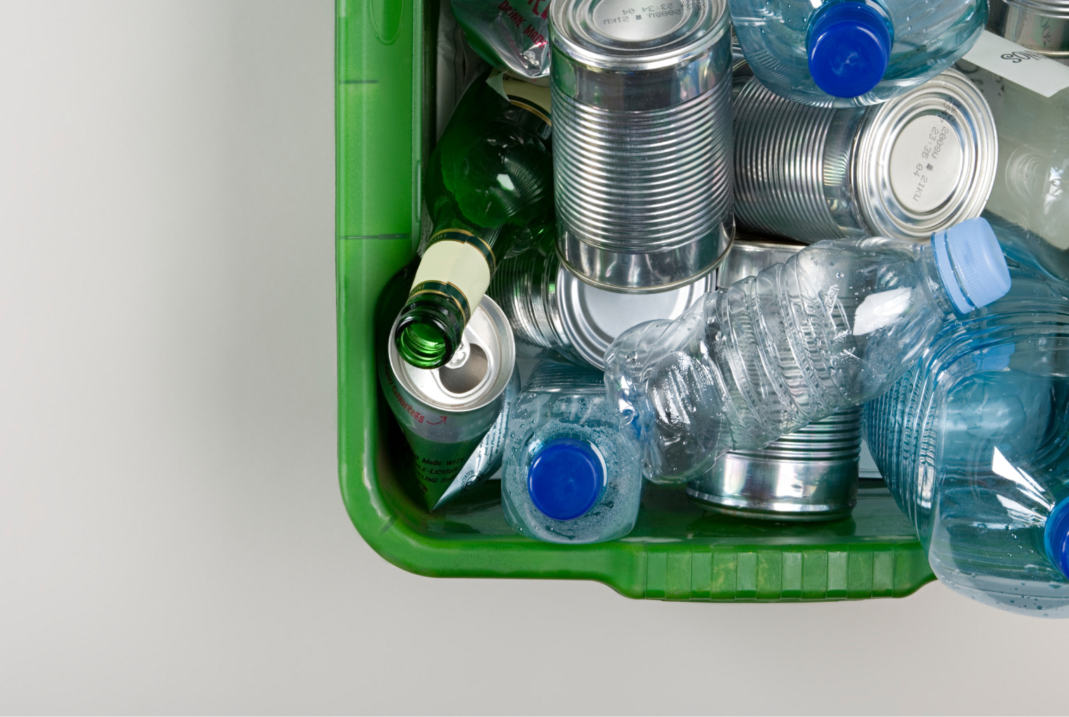 a top-down view of a green bin filled with recylables